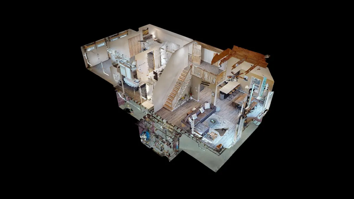 This image captures a welcoming open-plan area featuring a staircase, living area, dining area, and kitchen. The layout suggests a central gathering space ideal for families to come together for meals, games, and conversation. Ample natural light and warm, inviting decor create a sense of comfort and connection.
